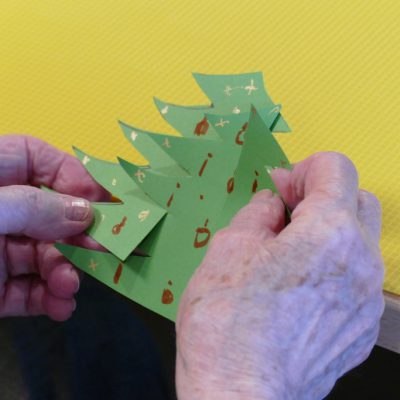 Eine Bewohnerin bastelt einen Tannenbaum.