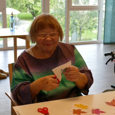 Bewohnerin bastelt Herbstdeko